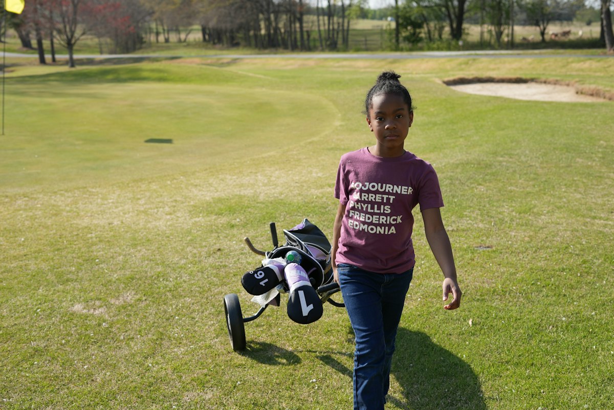 A young golfer practicing on the range